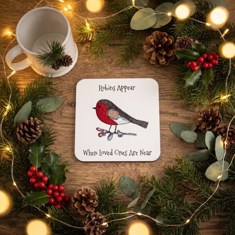 Robins Appear When Loved Ones Are Near coaster framed by a Christmas wreath of pine cones and berries