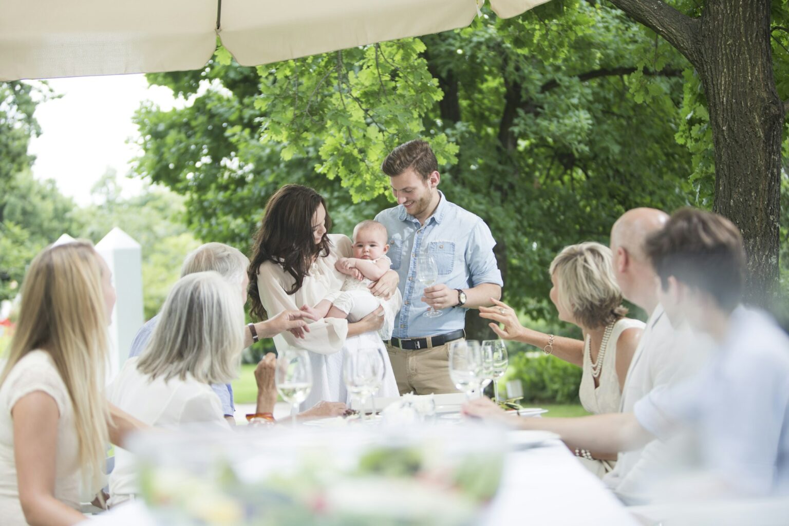 Baby being introduced to family on a garden party
