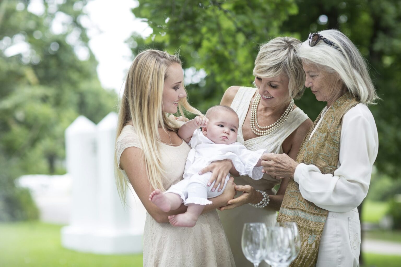 Christening or naming ceremony - Three women gathering around baby celebrating