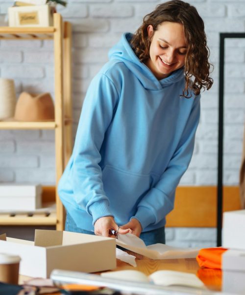 Close-up of preparing a parcel on the table. Woman online store, small business owner, entrepreneur.